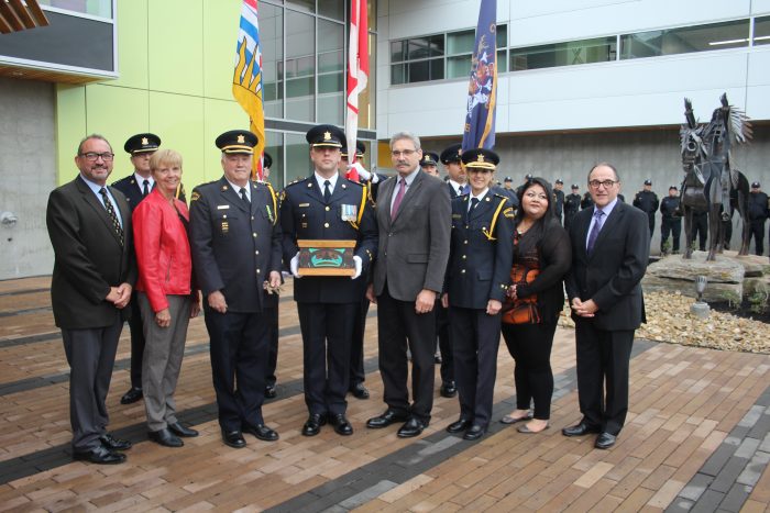 Dignitaries and Colour Guard pose for a photo.